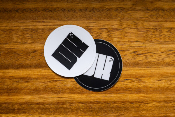 2025 DK logo black and white stickers on a wooden table