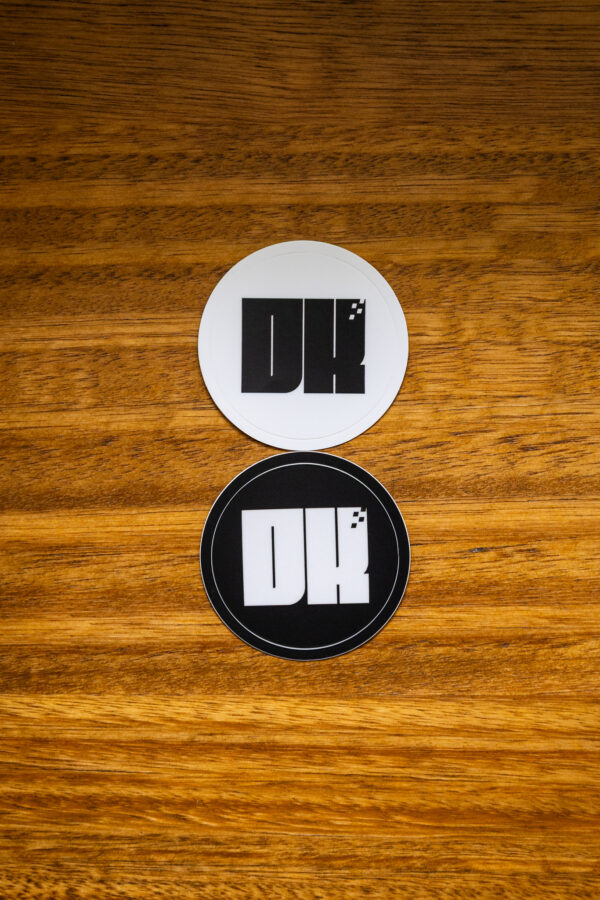 2025 DK logo black and white stickers on a wooden table