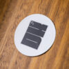 2025 DK logo white sticker on a wooden table