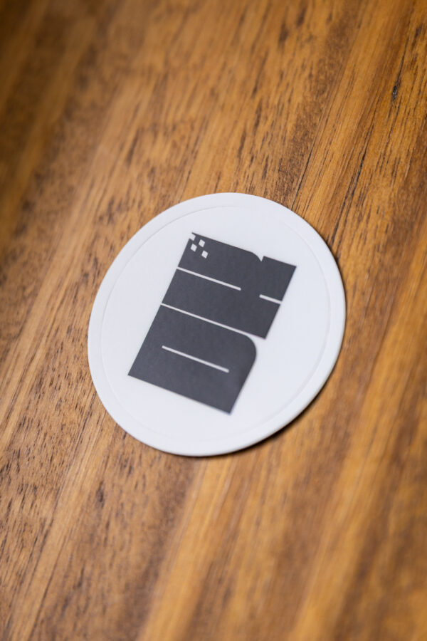 2025 DK logo white sticker on a wooden table