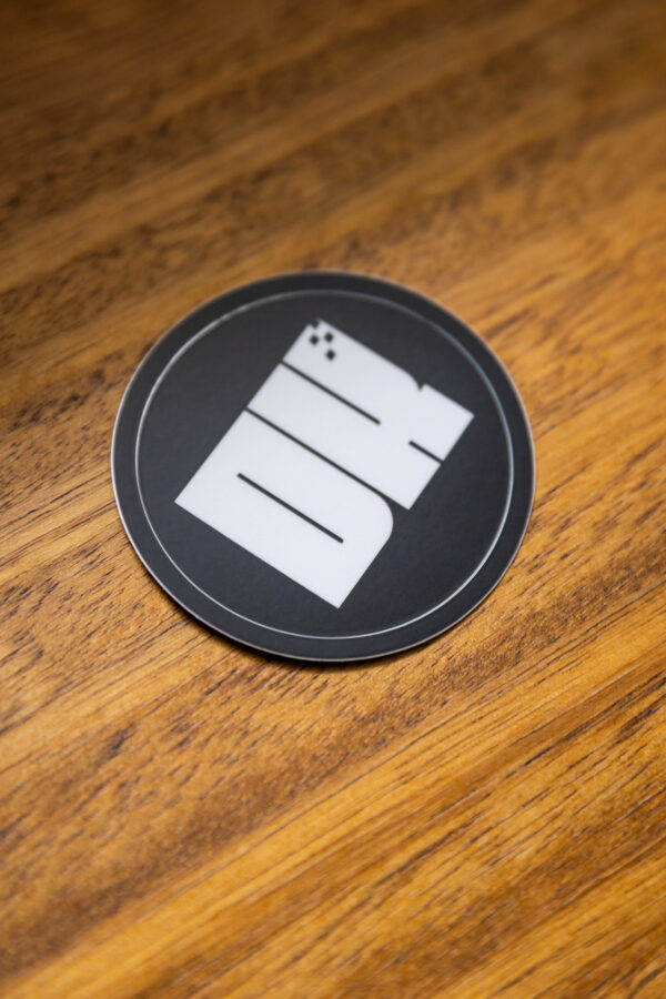 2025 DK logo black sticker on a wooden table